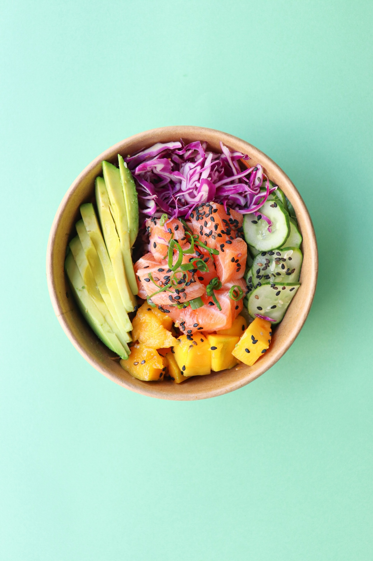 Overhead flat lay of fresh seasonal vegetables, herbs, lemons and olive oil on a cream linen background